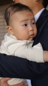 Sho on the baby's forehead